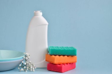 Mavi arka planda temizlik ürünleri. Evi, daireyi, ofisi temizliyorum. Plastik ambalaj.