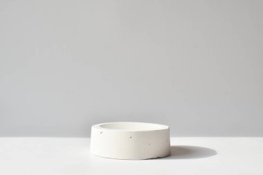 Geometrik beton figürlü beyaz bir podyum. Çimento kutusu olan bir sahne. Minimalist bir geçmiş. Kozmetik ürünleri sunumu.