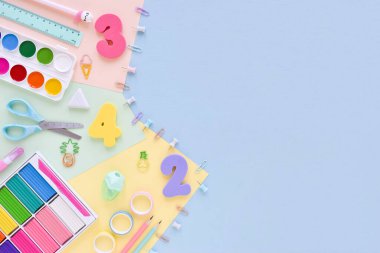 Pastel arka planında boş bir boşluk olan boş bir ofis masasının kırtasiye üst görünümü. Okula dönelim. Düz yatak.