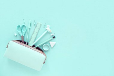 Açık mavi kalem kutusu ve açık renkli arka plan kırtasiyesi. Düz yatıyordu. Okula dönelim. Boşluğu Kopyala.