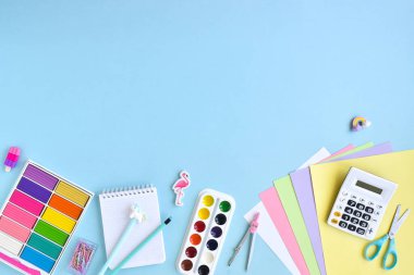 Pastel renkte okul malzemelerinin arka planı açık mavi arkaplan, metin için alan. Ofis malzemeleri. Okula dönelim. Düzdü..