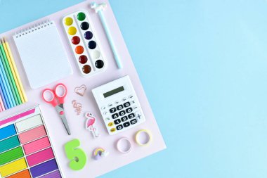 Pastel renkte okul malzemelerinin arka planı açık mavi arkaplan, metin için alan. Ofis malzemeleri. Okula dönelim. Düzdü..