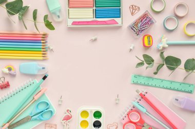 Pembe arka planda pastel renkli okul malzemeleri çerçevesi, mesaj için bir yer. Okula geri dön. Ofis malzemeleri. Düz konum, üst görünüm, kopyalama alanı.