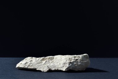 Podyum, sahnesi, taş bir vitrini ve minimalist bir arka planı olan siyah bir zemin. Kozmetik ürünleri sunumu.