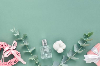 Sevgililer Günü için bir tebrik kartı. Okaliptüsten yapılmış metin için çerçeve, yeşil arka planda hediye ve kalp. Düz konum, üst görünüm, kopyalama alanı.