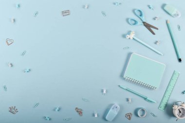 Açık mavi bir arkaplanda Pastel renkte okul malzemeleri çerçevesi, metin için alan. Düz konum, üst görünüm, kopyalama alanı.