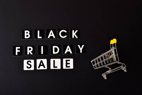 На черном фоне надпись Черная пятница распродажа и коляска из супермаркета.