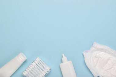 Çocuk bakım aksesuarlarıyla dolu yumuşak mavi arka planda boş bir defter. Düz düzen, üst görünüm, kopyalanacak bir yer.