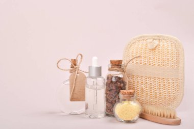 Sıfır kayıp. Doğal bir kozmetik ürününün afişi. Cilt bakımı için serum, tuz ve fırçalar, volkanik aromaterapi taşı ve cam şişedeki bitkiler..