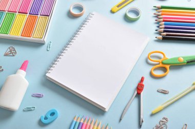 Açık mavi arkaplanda metin için boşluk olan kırtasiye malzemesi. Okula dönelim. Düz yatış, üst görünüm