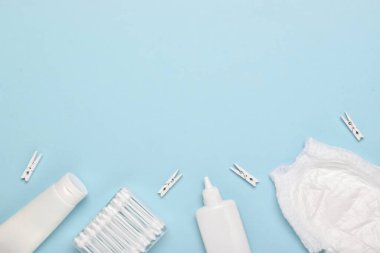 Beyaz ataçlar arasında bebek bezi ve hijyen ürünleri var. Çocuklar için vücut bakım aksesuarlarıyla donatılmış. Düz düzen, üst görünüm, kopyalanacak bir yer.