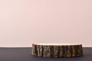 Bej bir arkaplan üzerine sunum için gölgeli yeşil bir dalı olan tahta bir sahne. Podyum doğal malzemeden yapılmıştır ve metin için yer vardır. Asgari markalaşma sahnesi.