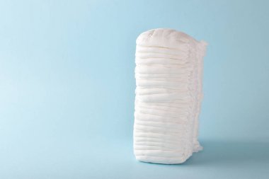 Açık mavi arka planda tek kullanımlık çocuk külotu yığını. Kopyalama. Minimalizm.