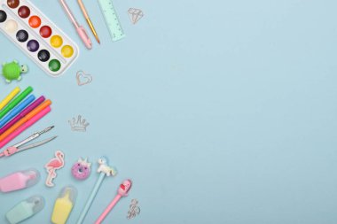 Açık mavi arkaplanda metin için alanı olan bir kırtasiye malzemesi ile arka plan. Okula dönelim. Düz plan, üst manzara, kopyalayacak bir yer. Düz düzen, üst görünüm, kopyalanacak bir yer.