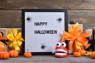 Mutlu Cadılar Bayramı. Cadılar Bayramı için balkabakları ve hediyelerle ahşap bir arka planda şölen kompozisyonu..