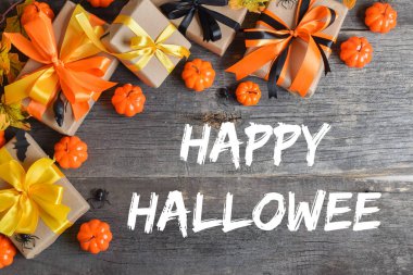 Mutlu Cadılar Bayramı. Cadılar Bayramı için balkabakları ve hediyelerle ahşap bir arka planda şenlik kompozisyonu. Üst görünüm.