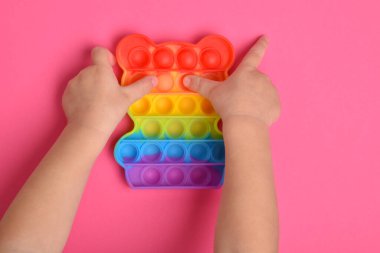 Popüler pop müzik oyuncağıyla oynayan çocukların yakın plan çekimleri. Renkli, esnek bir oyuncağı olan bir çocuk onu fırlatır..