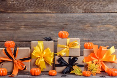 Mutlu Cadılar Bayramı. Cadılar Bayramı için balkabakları ve hediyelerle ahşap bir arka planda şenlik kompozisyonu. Boşluğu kopyala.