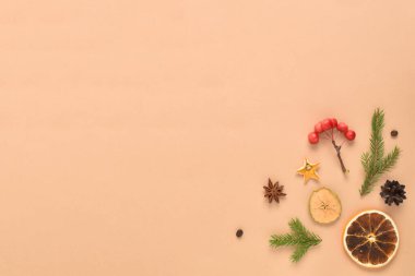 Dekorasyon ve dekorasyon için doğal nesnelerin Noel kompozisyonu bej bir zemin üzerine serilmiştir. Düz düzen, üst görünüm, kopyalanacak bir yer.
