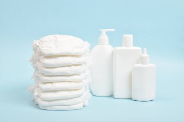 Çocuk hijyeni için çeşitli aksesuarlar. Yanlarındaki bebek bezlerinin büyük bir yığını bebek kozmetik şişeleri. Boşluğu kopyala