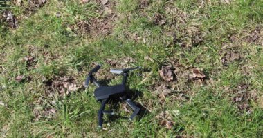 Quadrocopter çayırda durur ve pervaneleri çalıştırır.