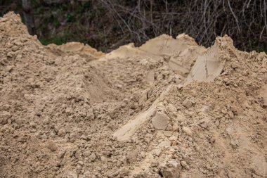 Yol kenarında yol yapımı için çakıl yığını var.