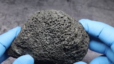 Bilim adamları koyu gri ay kayalarını yakından inceliyor.