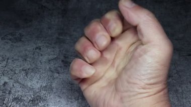 Adam elini bir yumruğa sıkıca tutar.