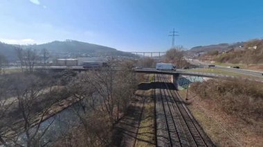 Yollar ve demiryolları mavi gökyüzünün altında ormanın içinden geçiyor.