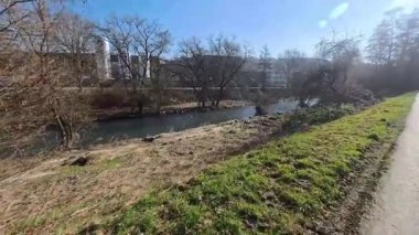 Sonbahar ormanı mavi gökyüzünün altında mavi bir nehirle kesişir.