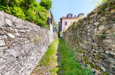 Maccagno, İtalya, taş duvarlı dar sokak ile manzara