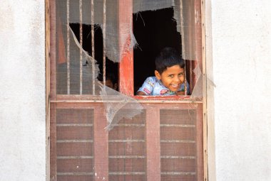 Sur, Umman - 15 Şubat 2020: Kimliği belirlenemeyen mutlu çocuk Sur 'un Umman Sultanlığı kentindeki eski evinin penceresinden gülümsüyor.