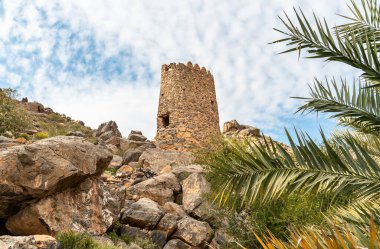 Tower ruins with Omani flag into the hills of the old village Misfat Al Abriyeen, Sultanate of Oman clipart