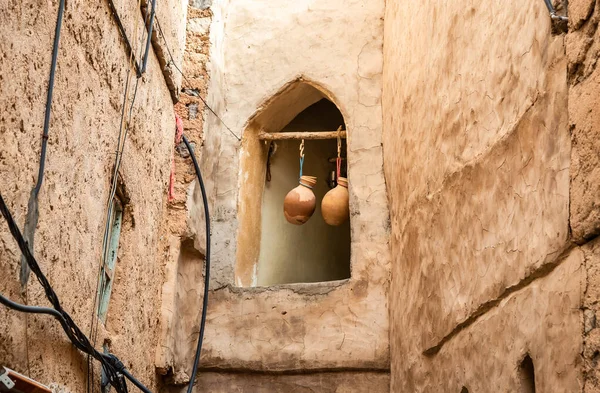 The oil and water jars handing in the window of old house in the Misfat Al Abriyeen village, Sultanate of Oman.