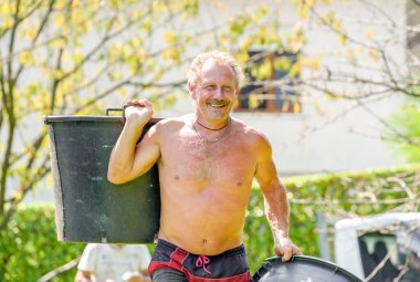 Bahçede çalışan gülen bahçıvan, güz bahçesi bakımı..