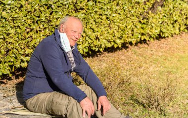 Coronavirus salgınından dolayı tıbbi koruyucu maskeli yaşlı bir adamın portresi. Yaşlılar için koronavirüs tehlikesi kavramı.