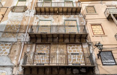Sicilya 'nın eski Palermo şehrinde eski bir evin balkonlarıyla yıkılmış bir duvar.