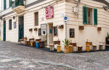 Alghero, Sardinya, İtalya - 10 Ekim 2025: Alghero 'nun tarihi merkezinde yer alan tipik İtalyan şarap barı, açık hava oturma ve Akdeniz cazibesiyle.