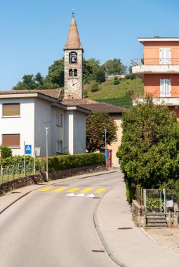 Bakire Meryem 'in Arınması Kilisesi ile Komano köyü manzarası, Ticino kantonu, İsviçre.