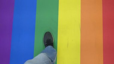 Gökkuşağı renkli zeminde yürüyorum. Kırmızı, turuncu, sarı, yeşil, mavi ve menekşe LGBT gurur bayrağının renkleri.