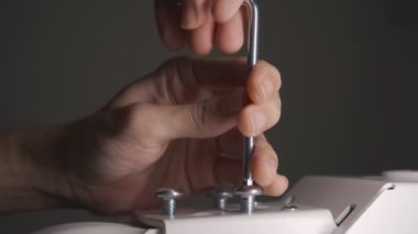 Bir adam büyü anahtarıyla vida kullanıyor.