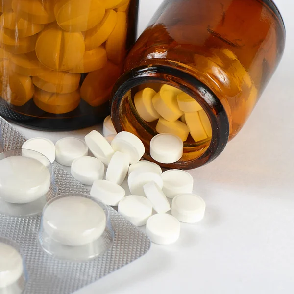 Tablety do skleněné nádoby, izolované na bílém — Stock fotografie