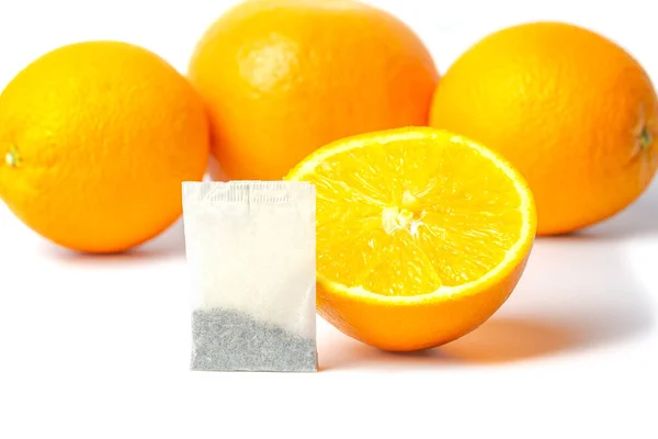 Té naranja en una bolsa. Bolso de té y naranjas sobre fondo blanco. —  Fotos de Stock