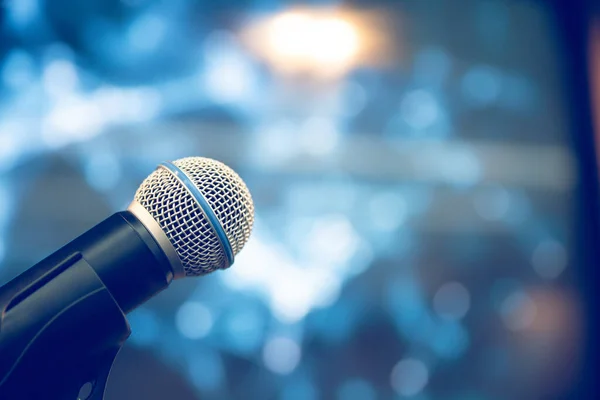 Public speaking backgrounds, Close-up the microphone on stand for speaker speech at seminar room with technology light background and blur bokeh.