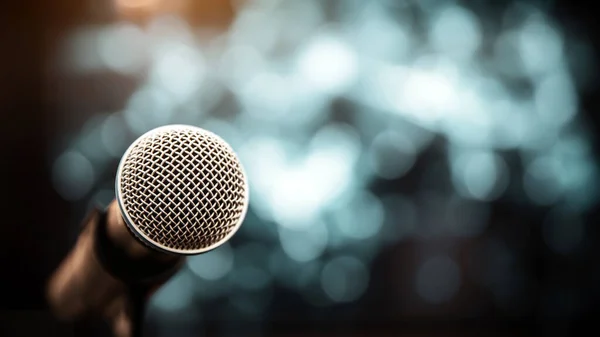 Public speaking backgrounds, Close-up the microphone on stand for speaker speech at seminar room with technology light background and blur bokeh.