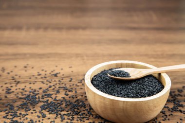 Sağlıklı yemek ve diyet kavramları için tahta kaşıkta siyah susam tohumları..