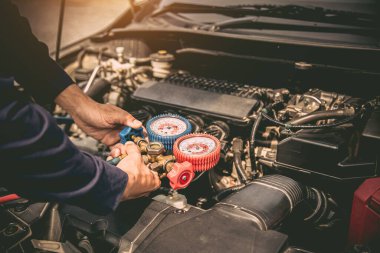 Otomobil tamircisinin eli araba klimalarını doldurmak için ölçüm manifoldunun göstergesini kullanacak. Tamir ve araba sigortası için düzeltme ve kontrol kavramları.