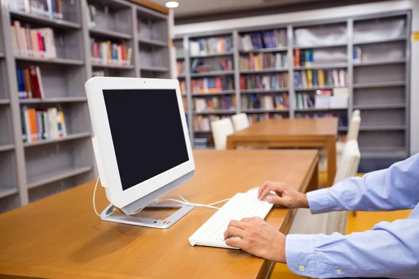 Close up the blank of monitor screen with hand of a man using computers on the desk or table in the library for finding information search and template for online shopping concepts.