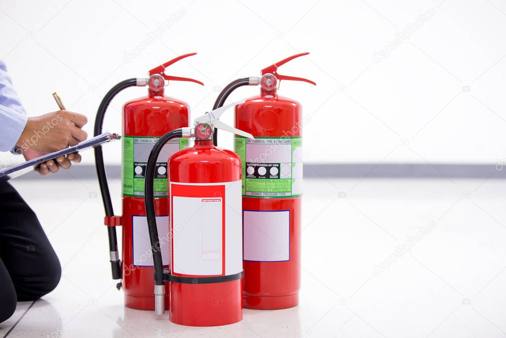 Fire engineering checking pressure gauge indicator chemical liquid level of fire extinguishers tank in the building concepts of prevent case for emergency and safety rescue and fire training.