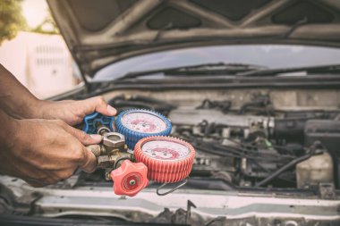 Otomobil tamircisinin eli araba klimalarını doldurmak için ölçüm manifoldunun göstergesini kullanacak. Tamir ve araba sigortası için düzeltme ve kontrol kavramları.